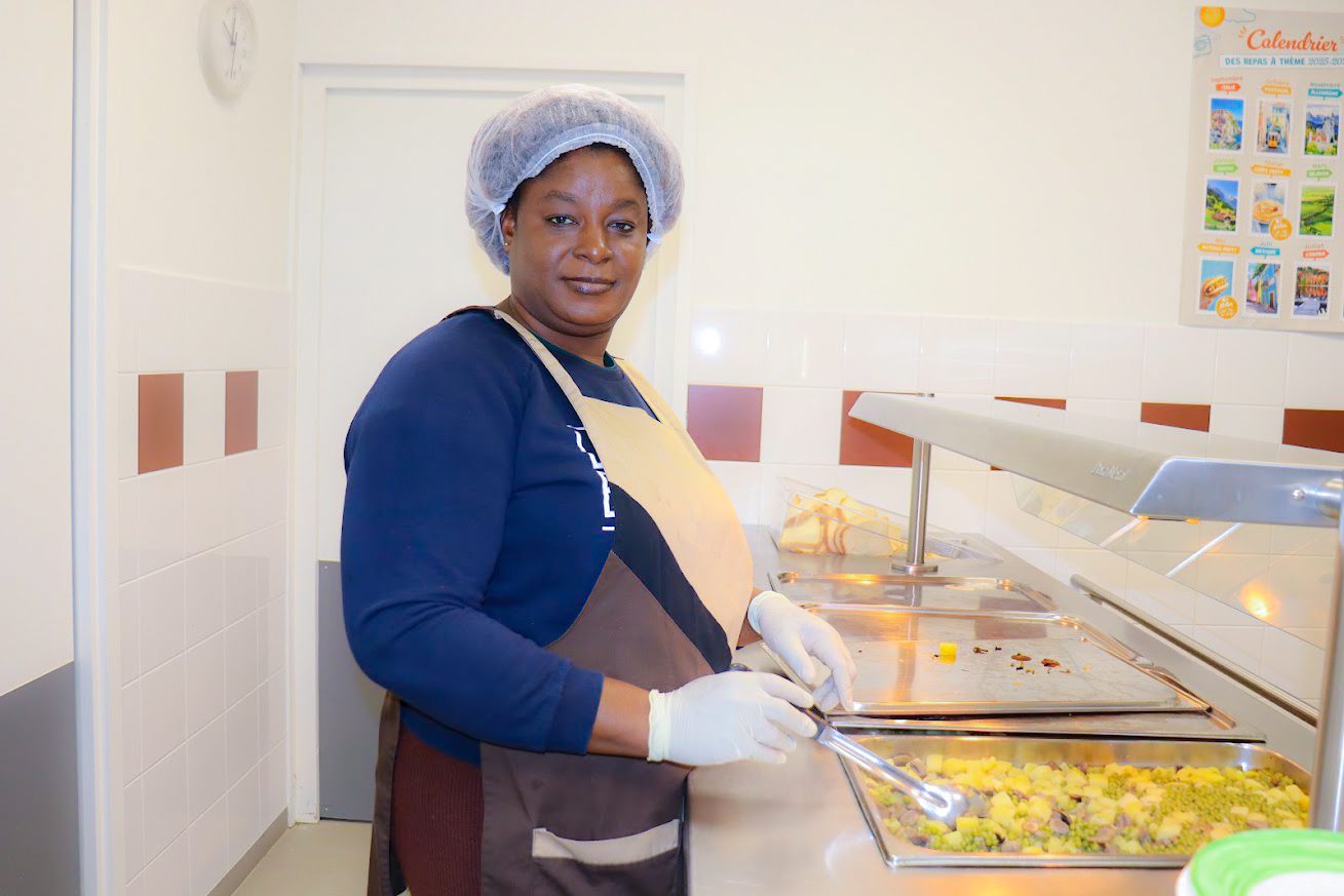 Agente de restauration scolaire au comptoir du self